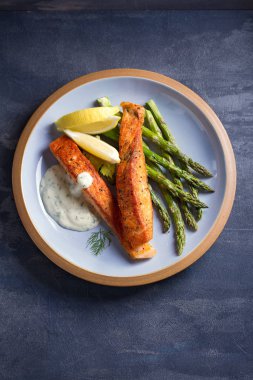 Kuşkonmaz ve limon dilimli lezzetli somon balığı filetoları.