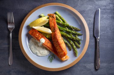 Kuşkonmaz ve limon dilimli lezzetli somon balığı filetoları.