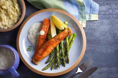 Kuşkonmaz ve limon dilimli lezzetli somon balığı filetoları.