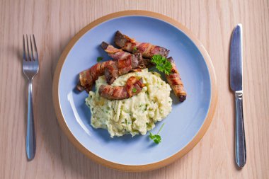 Domuz pastırmasına sarılı kuzu ciğeri patates püresi. Yukarıdan görüntüle, üstten