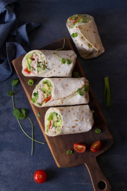 Avokado, domates ve buzdağı marullu tavuk dürümü. Tortilla, burrito, sandviç, rulo köfte. Yukarıdan görüntüle, üstten