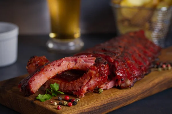 Rack of ribs, barbecue sauce, fries and light beer. Horizontal image
