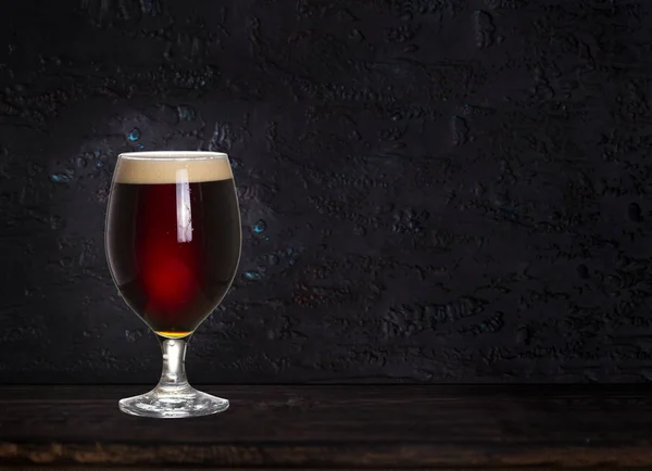 Glass of beer on wood dark background with copyspace for text