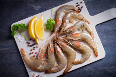 Tahtada pişirmek için malzemeli taze çiğ karides. Deniz ürünleri.