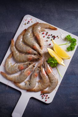 Tahtada pişirmek için malzemeli taze çiğ karides. Deniz ürünleri.