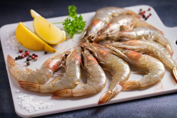 Tahtada pişirmek için malzemeli taze çiğ karides. Deniz ürünleri.