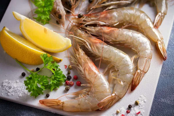 Tahtada pişirmek için malzemeli taze çiğ karides. Deniz ürünleri.