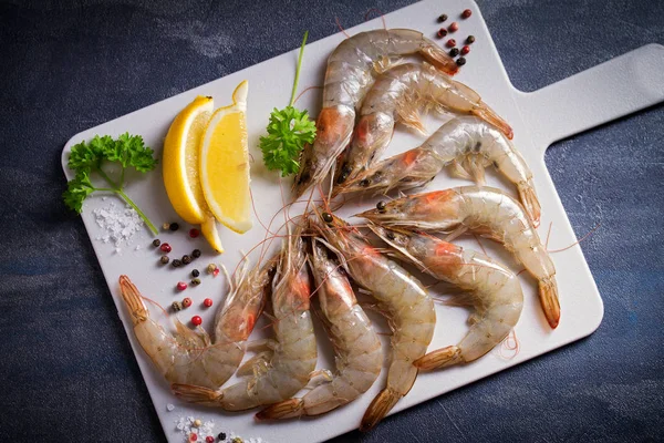 Tahtada pişirmek için malzemeli taze çiğ karides. Deniz ürünleri.