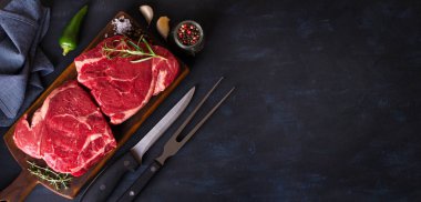 Çiğ et, ahşap doğrama tahtasında biftek. Yukarıdan bak, yukarıdan. Boşluğu kopyala