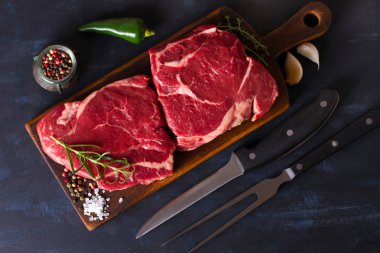 Çiğ et, ahşap doğrama tahtasında biftek. Yukarıdan görüntüle, en üstten