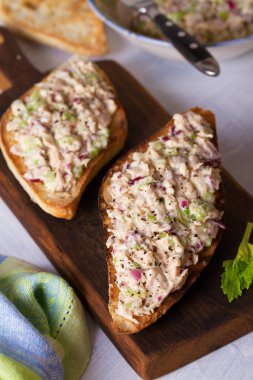 Servis panosunda ton balıklı sandviçler, beyaz arka plan. Dikey resim