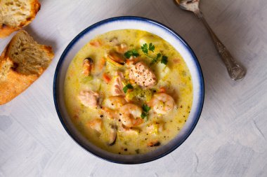 Beyaz arka planda somon balıklı bir kase deniz ürünleri çorbası. Düz görüntü. Boşluğu kopyala, metin için yer aç