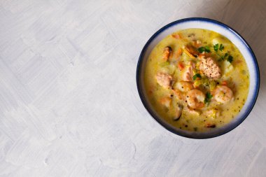 Beyaz arka planda somon balıklı bir kase deniz ürünleri çorbası. Düz görünüm