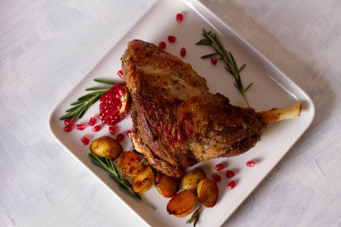 Patates, nar ve biberiyeli kuzu rostosu. Yukarıdan görüntüle, en üstten