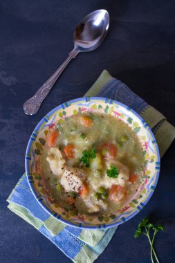 Koyu gri arka planda sebzeli tavuk güveci. Tepedeki dikey resim