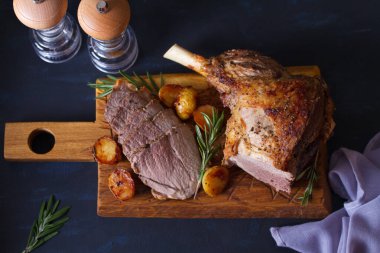 Ahşap tahtada patates ve biberiyeli kuzu rostosu. Yukarıdan görüntüle, en üstten