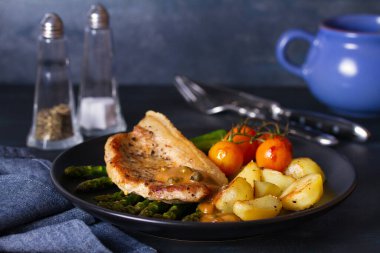 Biber soslu domuz pirzolası, kuşkonmaz, patates ve domates.