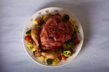 Domuz pastırması ve sebzeye sarılı göğüslü kızarmış tavuk. Yukarıdan görüntüle, en üstten