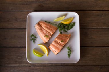 Haşlanmış somon filetosu. Beyaz tabakta haşlanmış somon balığı. Sağlıklı diyet balık yemeği. Yukarıdan bak, en iyi stüdyo çekimi.