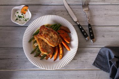 Kuşkonmaz ve tatlı patatesli sarımsaklı domuz pirzolası. Yukarıdan görüntüle, en üstten