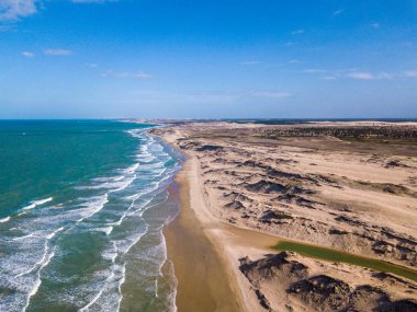 Dalgaları ve mavi gökyüzü olan güzel sahil