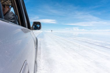 Bolivya 'daki Salar de Uyuni' de su ile kaplı araba ve bulutların yansımaları