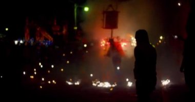 Patlayan Havai fişeklerle boğa kostümlü adam gibi koşan insanlar yaklaşıyor.