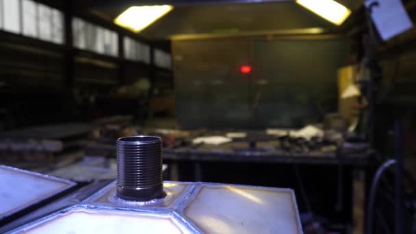 détail sculpté sur le fond d'une table de garage de travail avec de nombreux outils sales dans une grande pièce sombre spacieuse, masque, montre, faible éclairage 