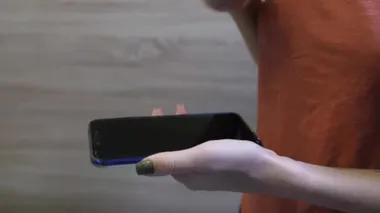 Kız telefonu dikkatlice peçeteyle siler.