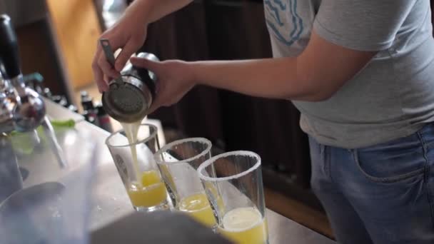 Bartender White Man Pours Yellow Juice Shaker Sieve Three Glasses — Stock Video