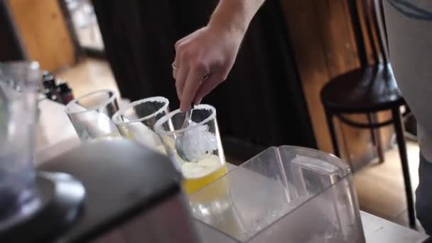 Barman Homem Coloca Gelo Com Uma Colher Copos Com Suco — Vídeo de Stock