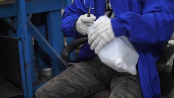 Ein Handschuhbehandschuhter Arbeiter Schneidet Überschüssiges Plastik Manuell Aus Einem Kanister — Stockvideo