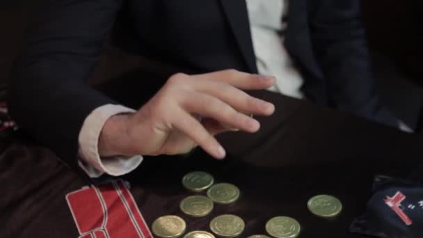 Mână Sortează Monedă Aur Între Degete Fundalul Altor Monede Întinse — Videoclip de stoc