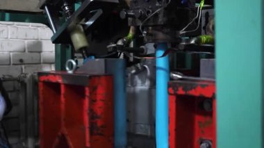 Ekstrüzyon ekipmanında plastik tankların patlatılması. Erimiş beyaz plastik bir tüp gibi baskı formuna sokulur ve hava üflenir ve şişenin şekli verilir.