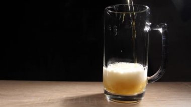 Bira yavaşça bardağa dökülüyor, bardağı köpük ve kabarcıklarla dolduruyor. 180fps