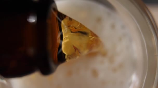 Verser de la bière dans un verre. Vue d'en haut. Un jet de bière est versé dans un verre, moussant et remplissant le verre .