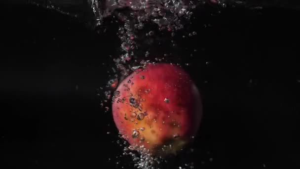 Rode Appels Vallen Het Water Met Spatten Bellen Zwemmen 180 — Stockvideo