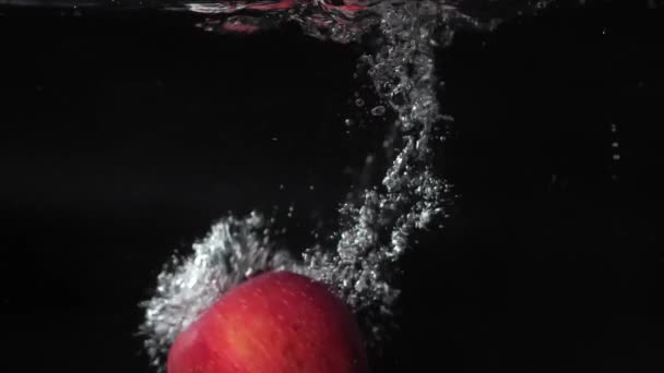 Manzanas Rojas Caen Agua Con Salpicaduras Burbujas Nadan 180 Fps — Vídeo de stock