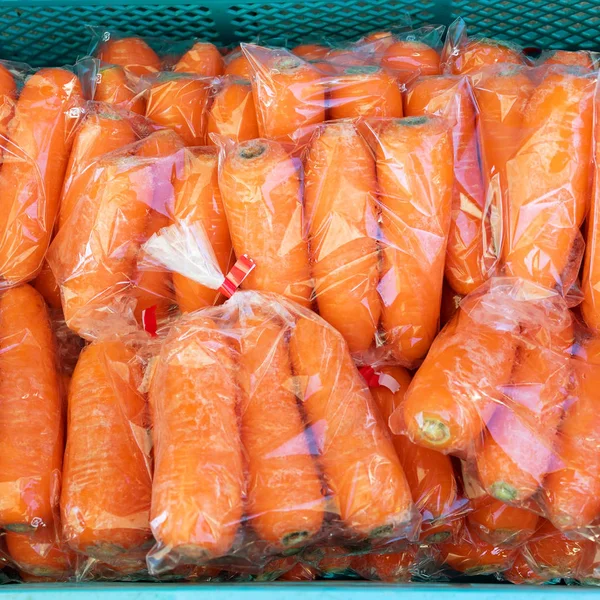 Gruppe frischer orangefarbener Möhren in Plastiktüte beim Bauern — Stockfoto