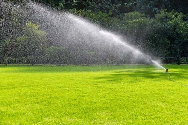 Bewässerungssystem Wasser auf einer grünen Wiese — Stockfoto