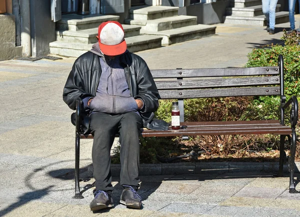 Homeless man sleeps on a bench — Stock Photo, Image