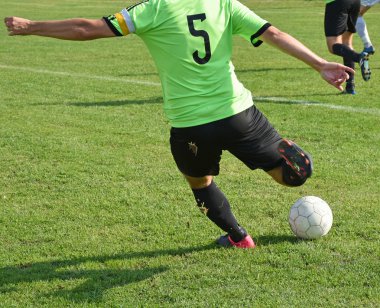 Futbolcu topa vuruyor.