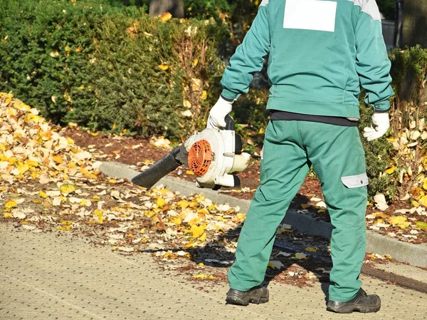 Street cleaner works in autumn