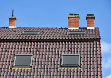 Evin çatı duman yığınları ile