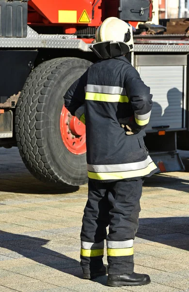 Firefighter stands next to a vehicle — Stock Photo, Image