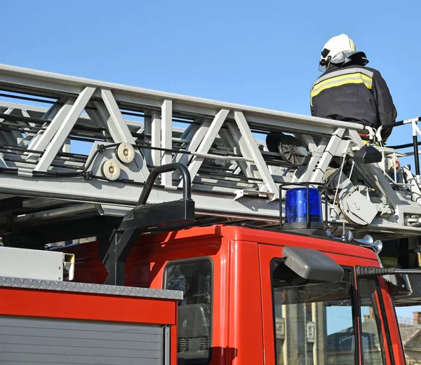 Bombero trabaja en la parte superior de un camión de bomberos — Foto de Stock