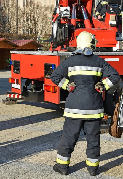 Firefighter stands next to a crane — Stock Photo, Image