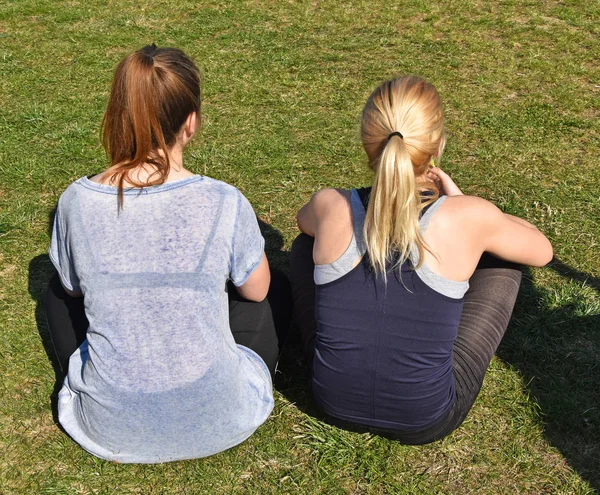Děvčata sedí v trávě — Stock fotografie