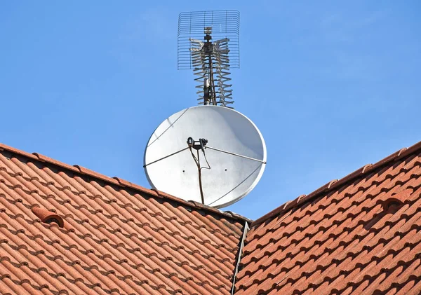 Satelliet schotel en TV-antenne op het dak — Stockfoto