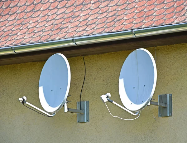 Dos antenas parabólicas en la pared — Foto de Stock